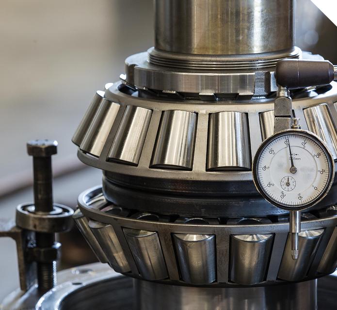 Tapered roller bearing cone and separate outer cup on a clean industrial surface Tapered roller bearing cone and separate outer cup on a clean industrial surface