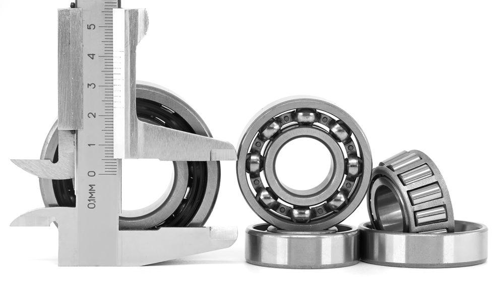 Automotive wheel hub bearing assembly with a passenger car in the background Automotive wheel hub bearing assembly with a passenger car in the background